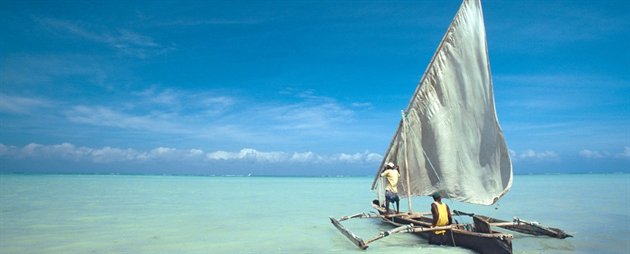 To mænd i en lille fiskerbåd sejler på det isblå hav ud for Tanzania To mænd i en lille fiskerbåd sejler på det isblå hav ud for Tanzania