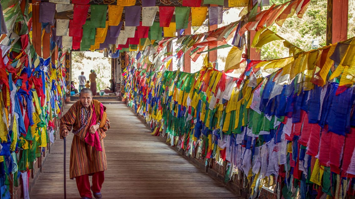 En ældre mand og farverige bedeflag i Bhutan