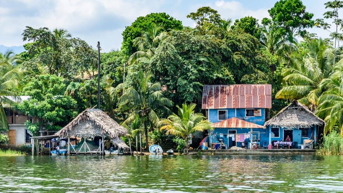 Små huse ved bredden af Rio Dulce