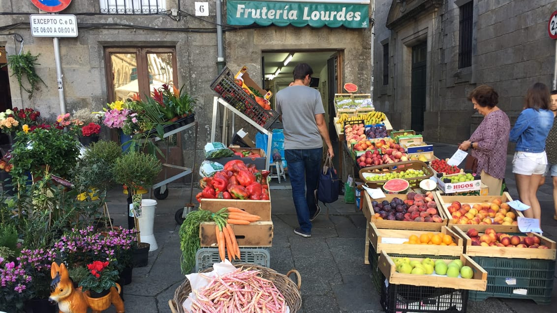 Der sælges grønsager foran butikken på en plads i Santiago de Compostela. Galicien, Spanien