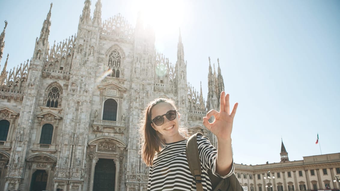 Ung backpacker ved domkirken, Duomo, i Milano