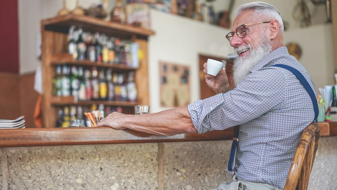 En ældre mand drikker kaffe på kaffebar i Italien