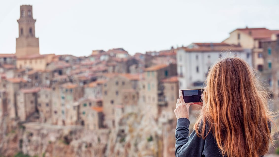 Kvinde tager billede af Pitigliano i det sydlige Toscana
