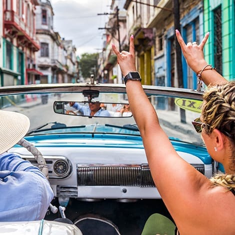 Ung i vintagebil i Havana i Cuba