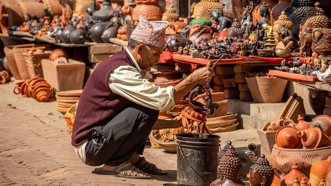 En mand maler keramik på Potter's Square i Bhaktapur