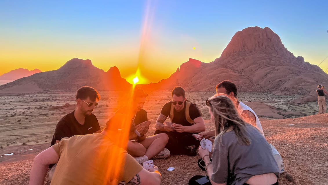 Kortspil i gruppen ved solnedgang ved Spitzkoppe
