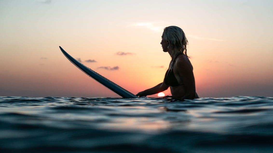 Surfer nyder solnedgangen, Indonesien